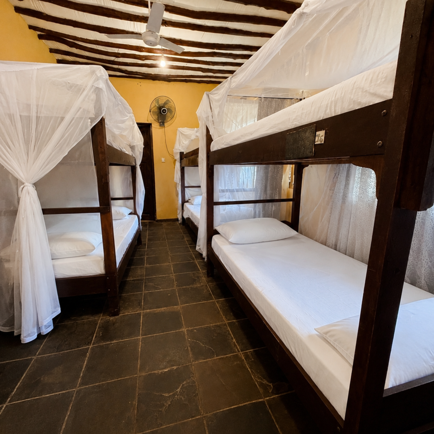 Room with sea view: beige sofa, balcony with small table, large windows overlooking the ocean.