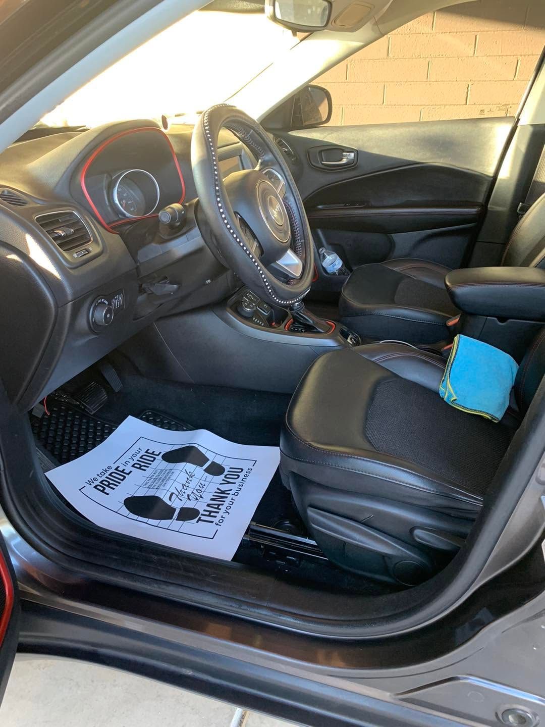 Car interior with black leather seats, steering wheel, and a blue cloth on the passenger seat.