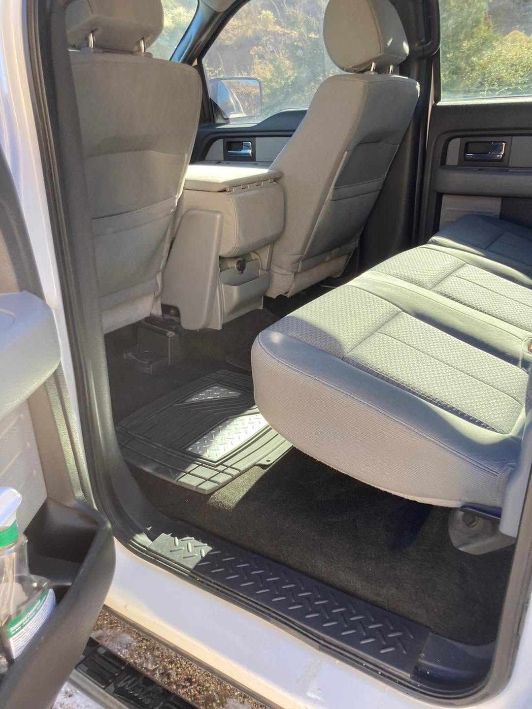 Car interior with front seats and a folded-down rear seat, showing a spacious open cargo area