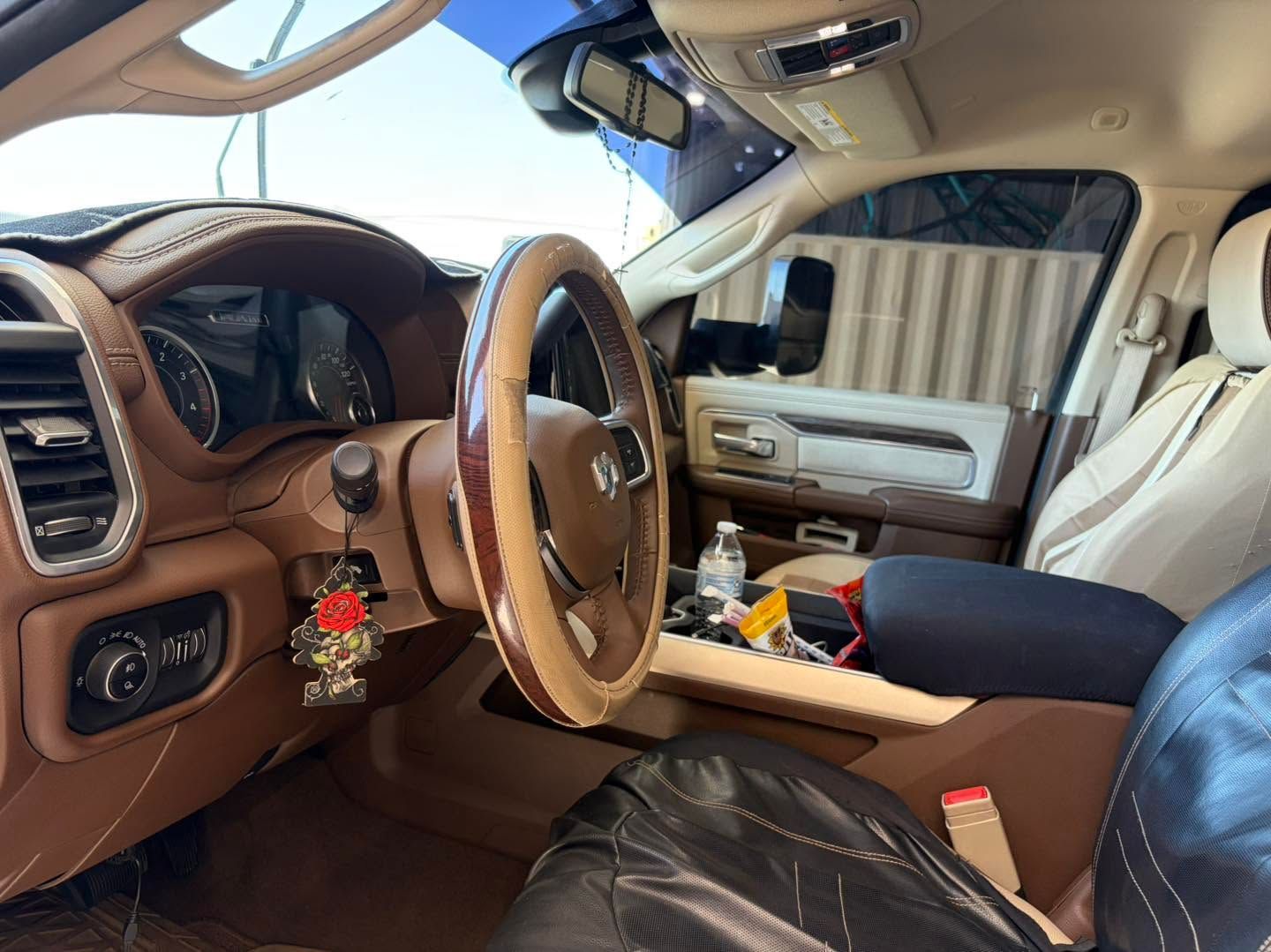 Luxurious tan leather car interior with steering wheel, dashboard, and front seats, viewed from the driver's side