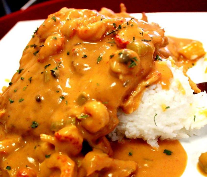 A close up of a plate of food with rice and sauce