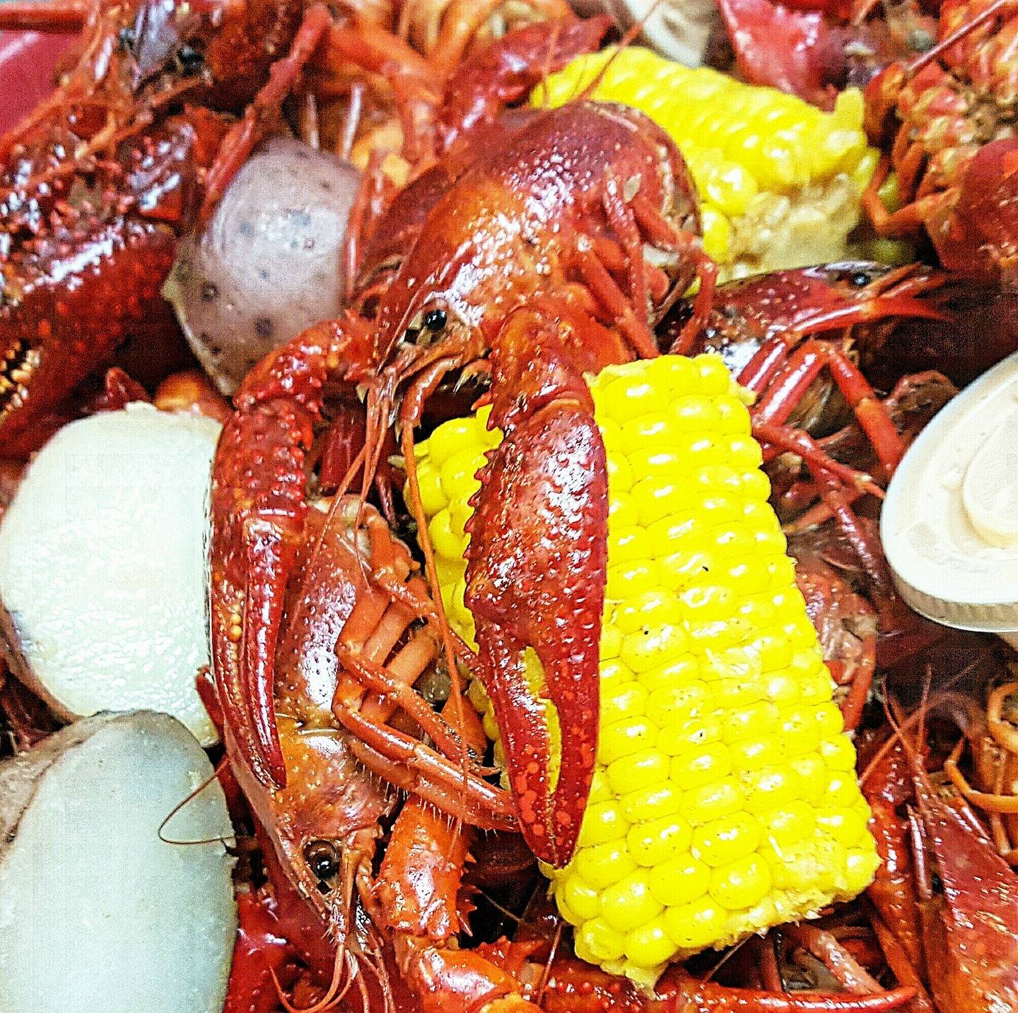 A close up of crawfish and corn on the cob