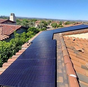 Solar panels installed on a red-tiled roof, sunny outdoor setting.