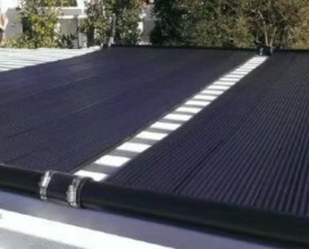 Person installing solar panel on a roof, connecting wires.