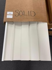 White corrugated metal panels in an open cardboard box labeled 