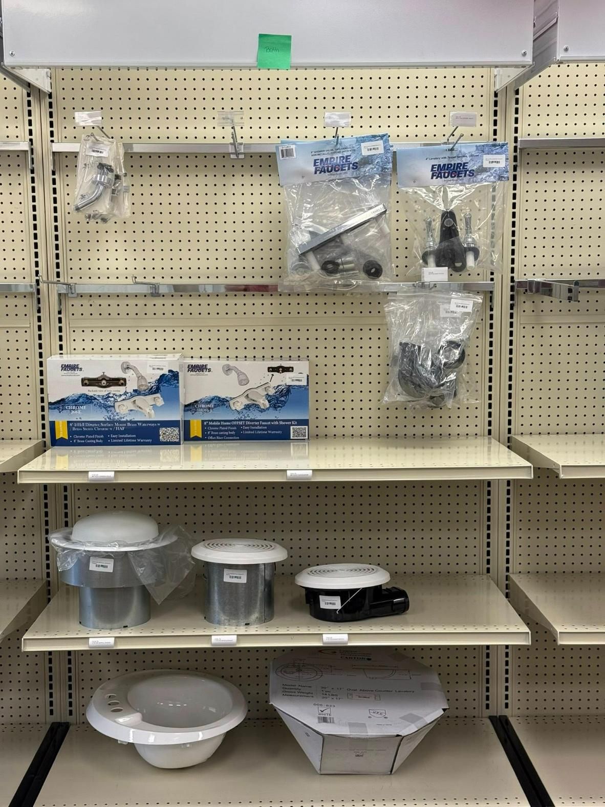 Shelves displaying various plumbing parts: faucets, valves, and bowl fixtures.
