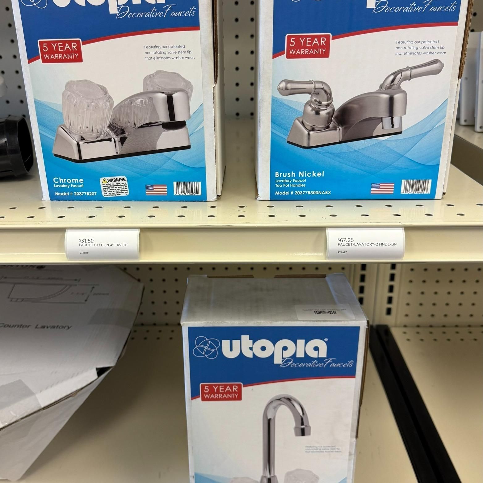 Boxes of Utopia bathroom faucets on a store shelf.