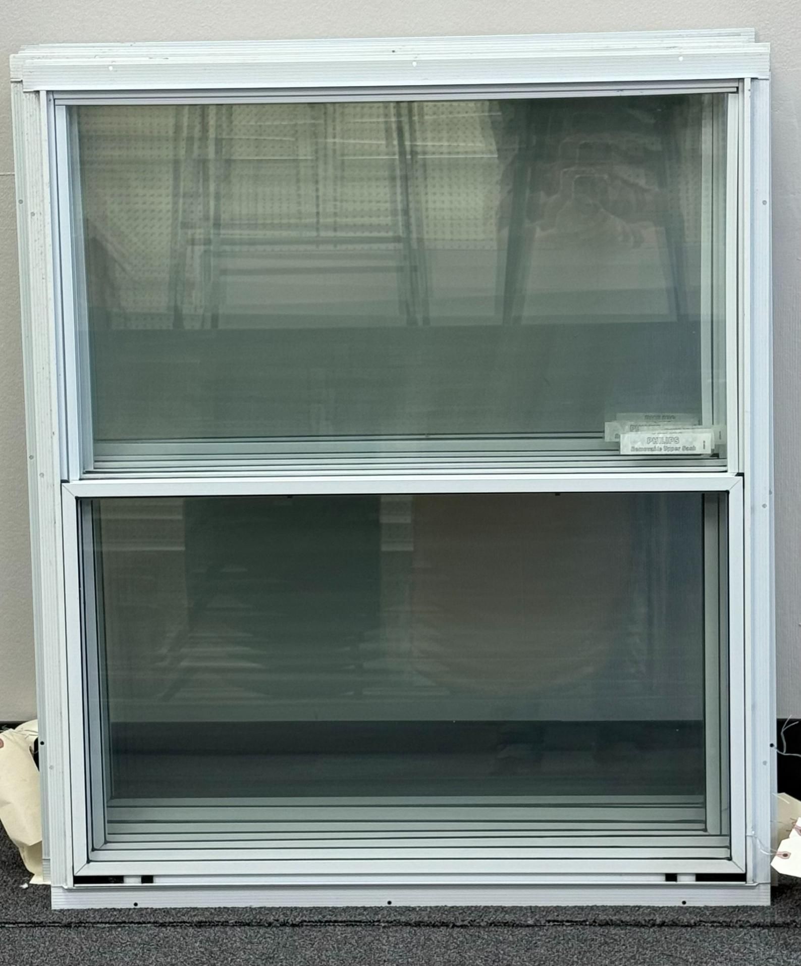 White double-hung window with a screen. The bottom pane is open. The setting is indoors.