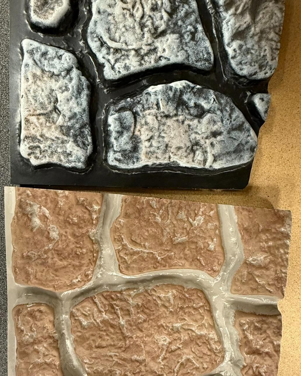 Two decorative stone panels, one gray and black, the other reddish-brown with white mortar.