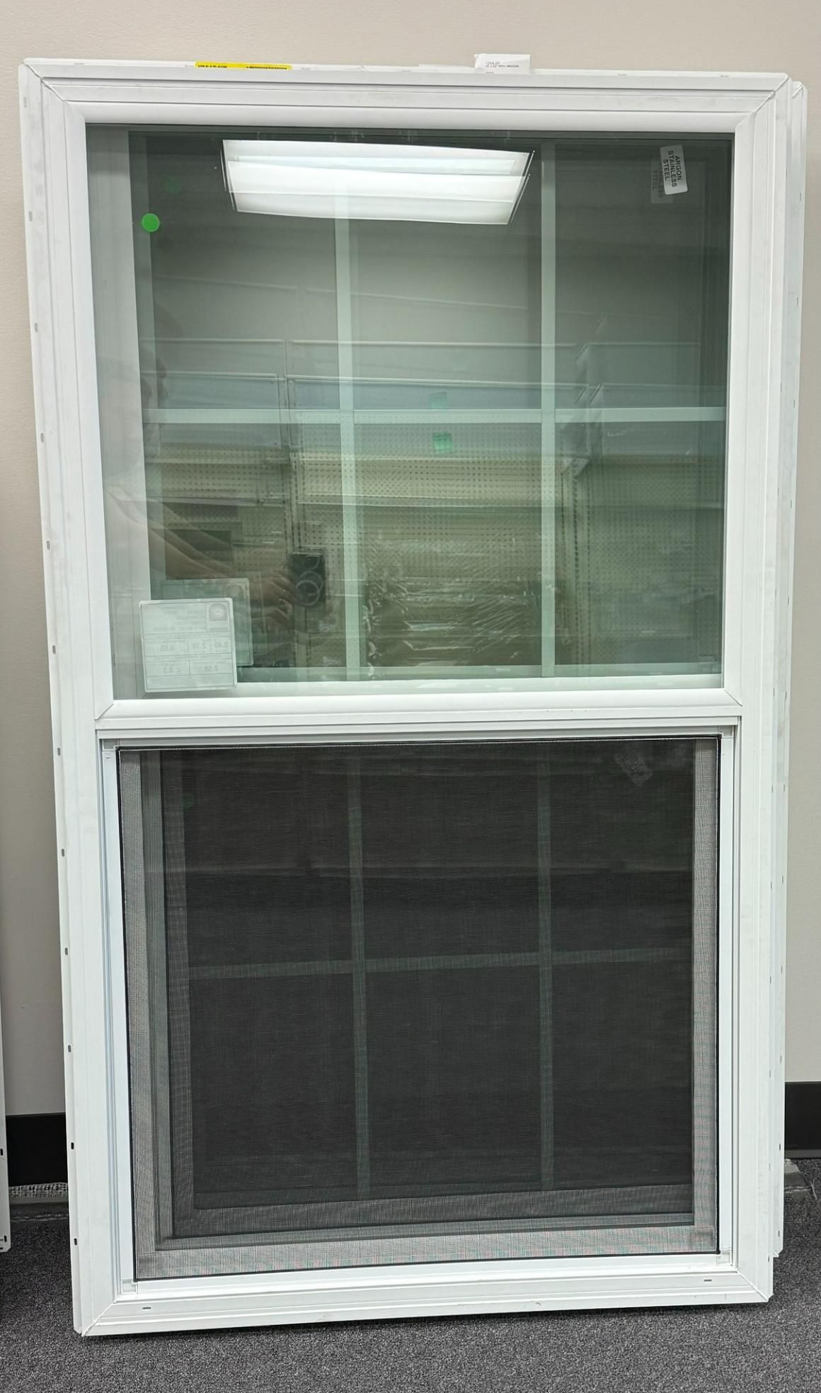 White double-hung window with a screen in the bottom half; set against a wall.
