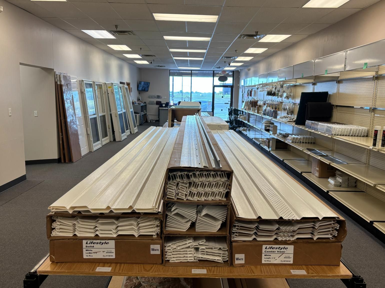 Interior of a store displaying stacked boxes and shelves with molding and doors.