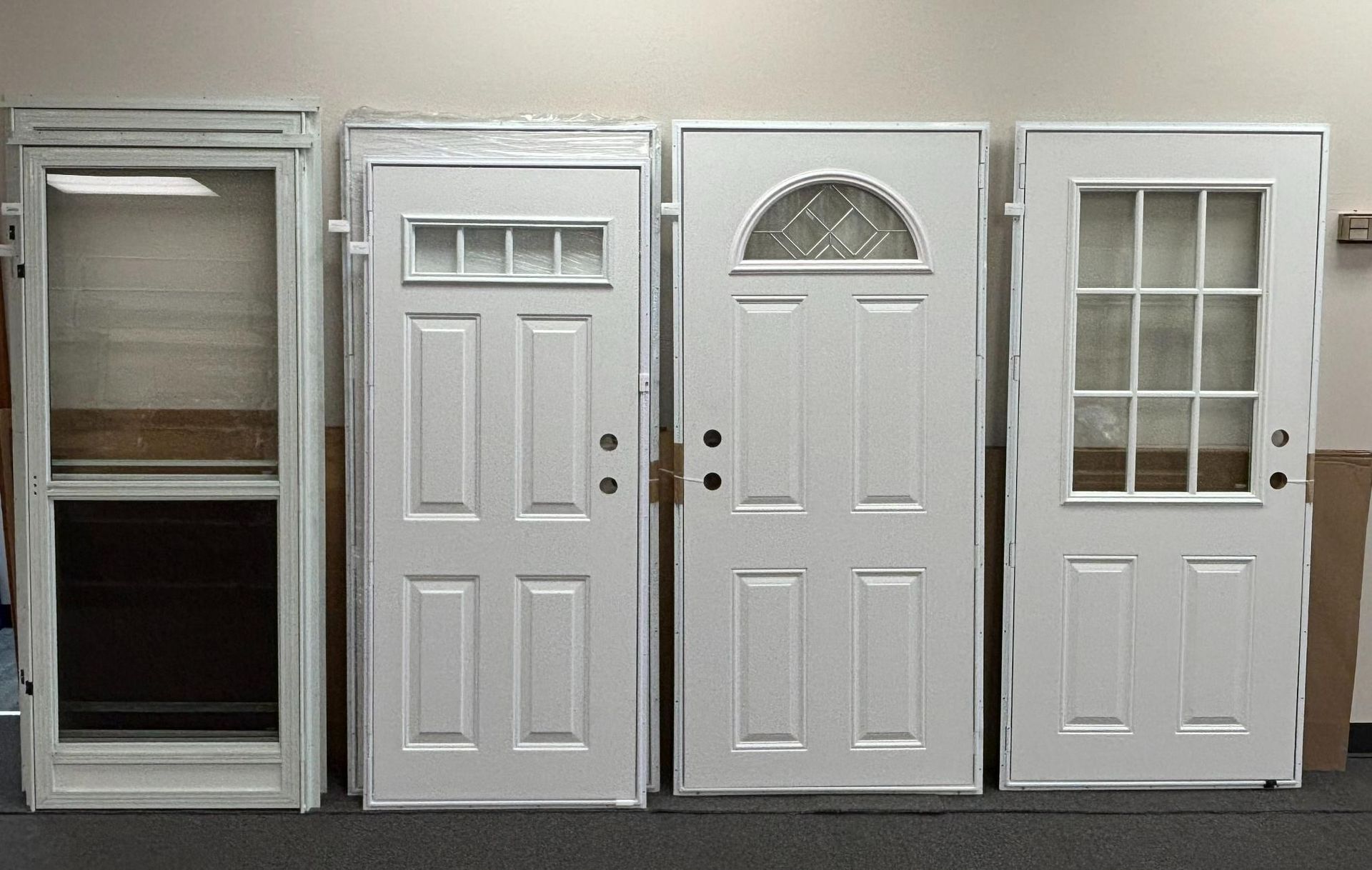 Four white exterior doors displayed indoors.