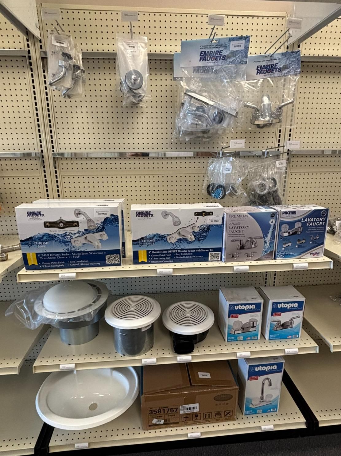 Hardware store shelving displaying plumbing fixtures like faucets and drains.