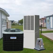 An air conditioning system consisting of a black outdoor unit, tall gray unit, and a silver device on a grassy lawn.