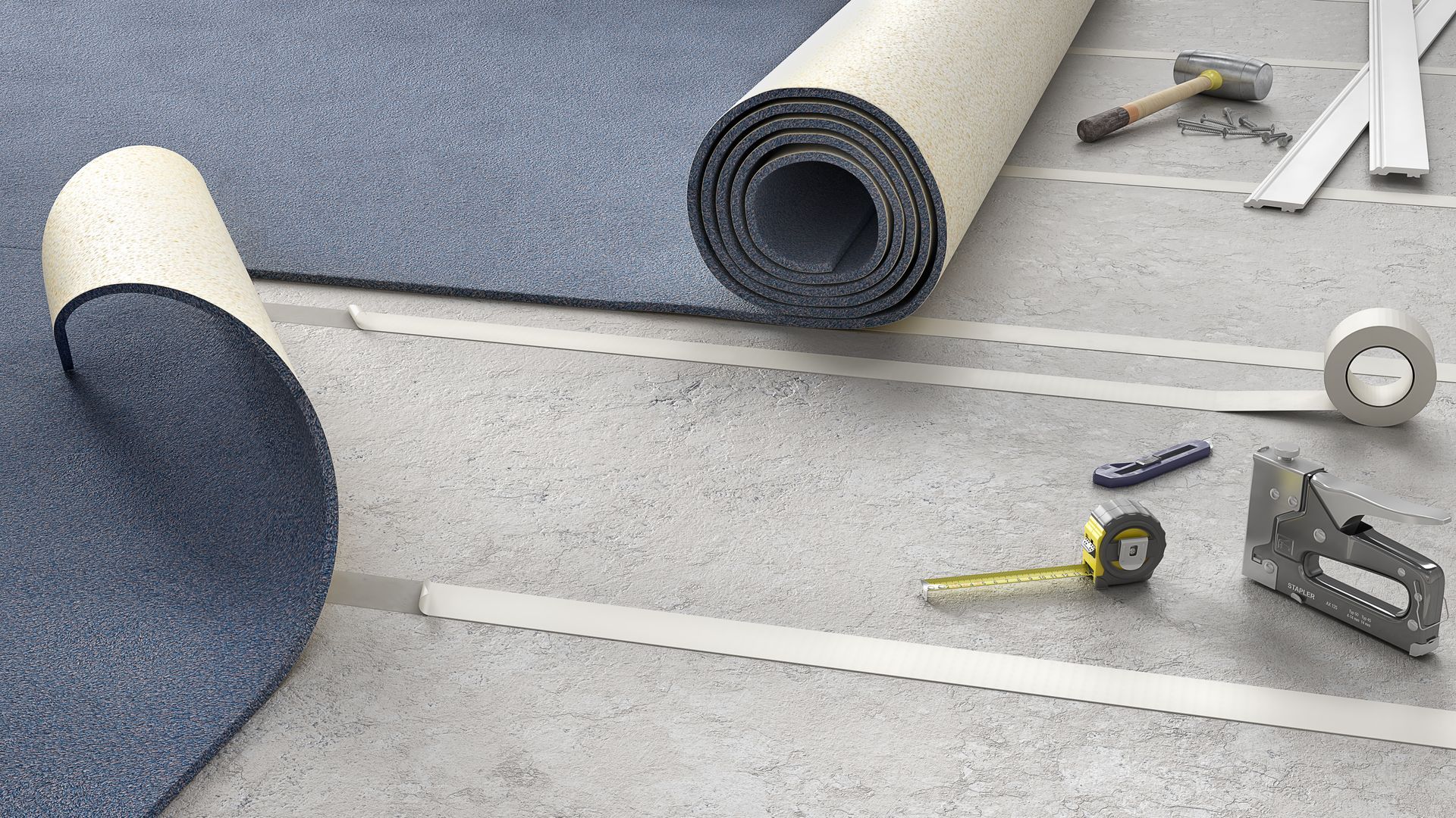 Carpet installation: rolled blue carpet, adhesive tape, tools on a concrete floor.