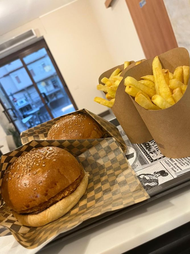 Hamburger e patatine fritte su un vassoio in un ristorante informale.