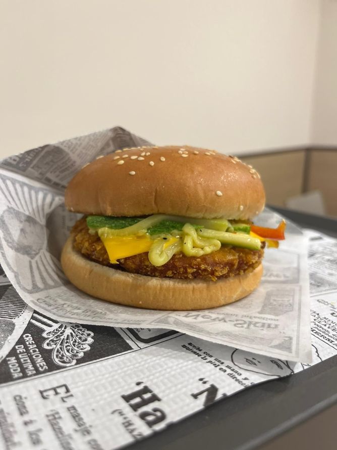 Cheeseburger con lattuga, pomodoro e salsa in un involucro sopra un tavolo