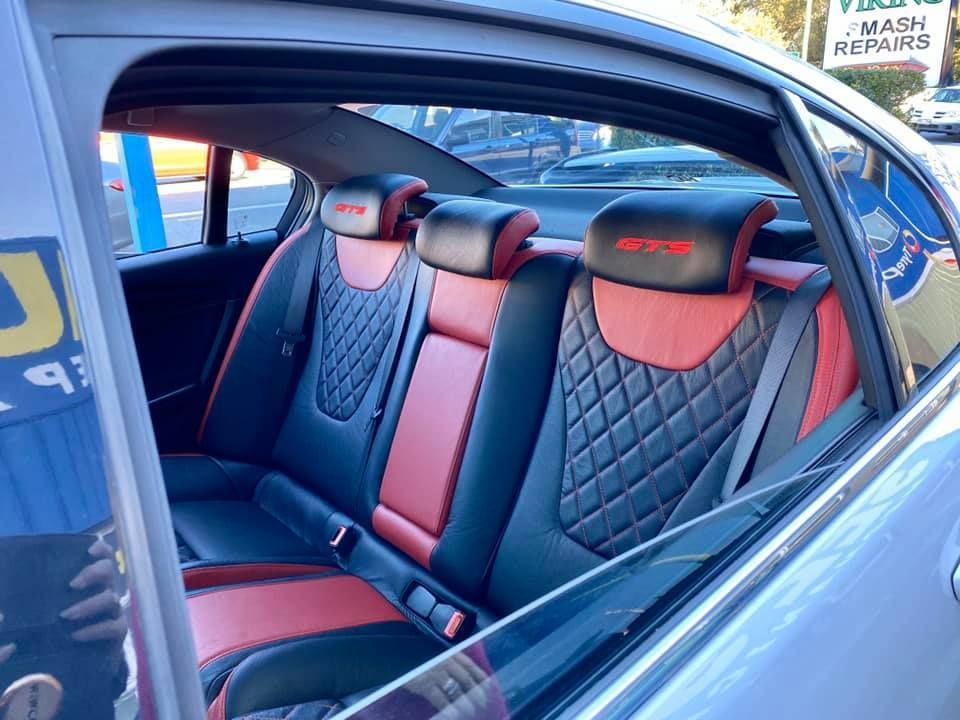 The Back Seat of a Car With a Red and Black Seat Cover — Currumbin Trimmers In Currumbin Waters, QLD