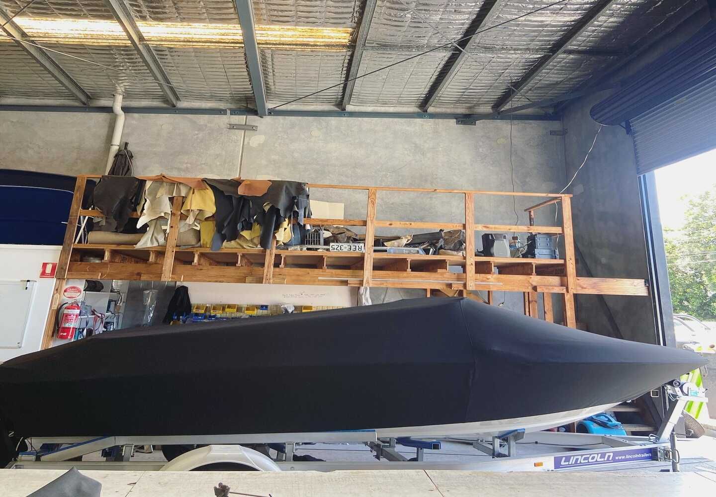 A Boat Is Covered In A Black Cover In A Garage — Currumbin Trimmers  In Currumbin Waters, QLD
