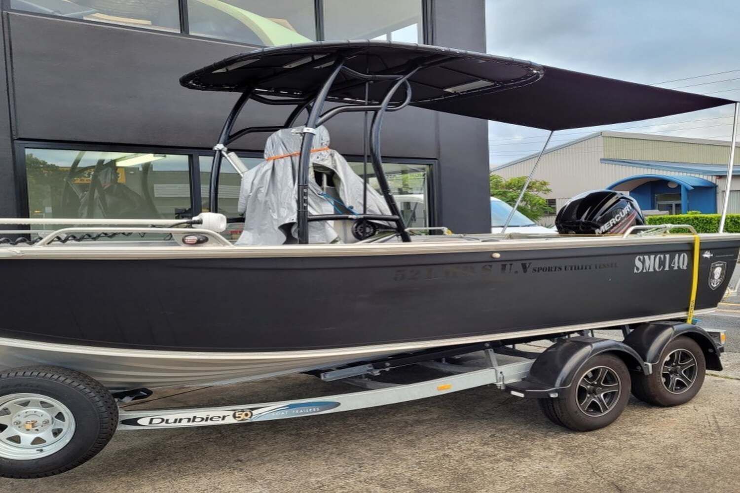 A Boat Is Parked On A Trailer In Front Of A Building — Currumbin Trimmers In Currumbin Waters, QLD