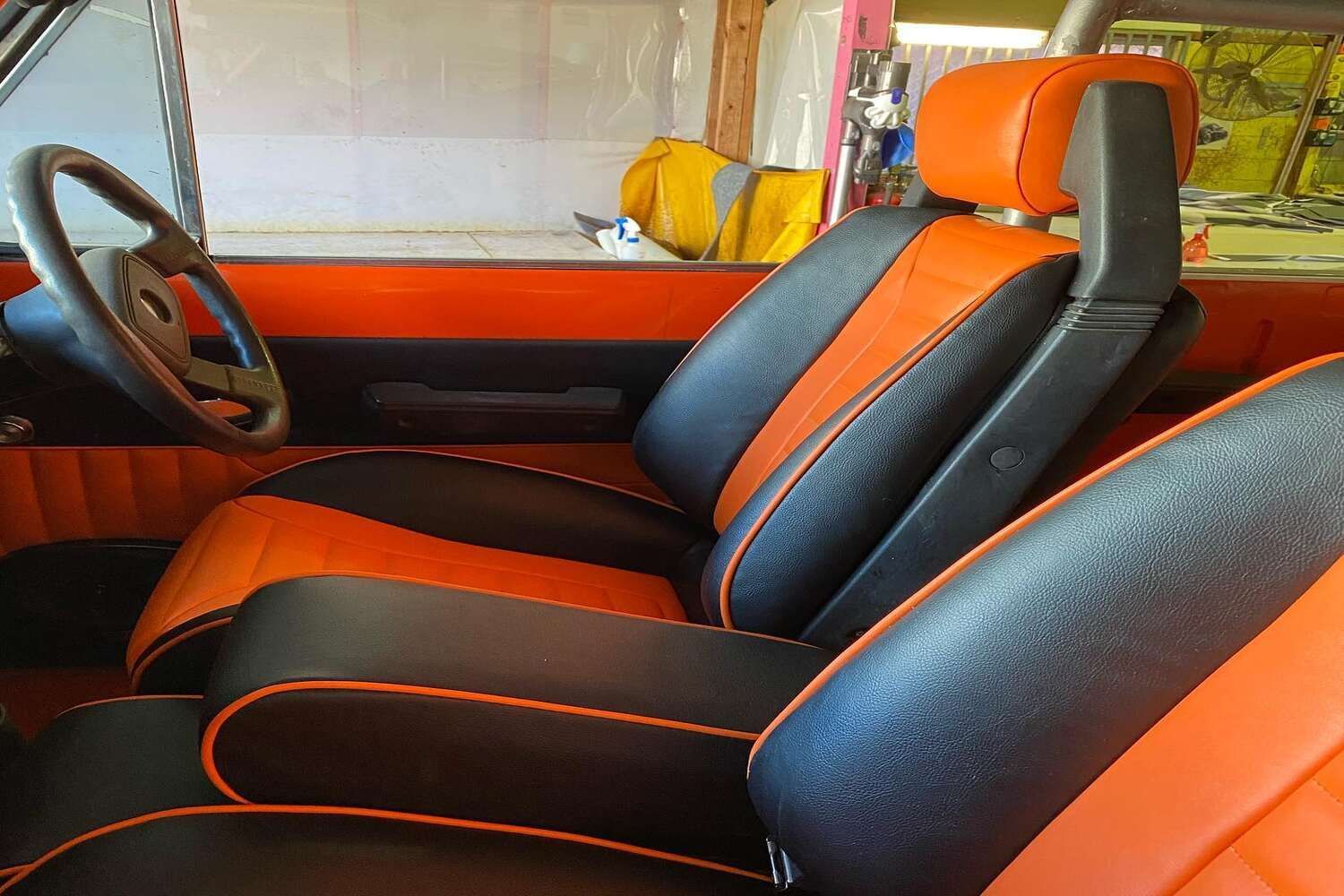 Black And Orange Seats In A Car With A Steering Wheel — Currumbin Trimmers In Currumbin Waters, QLD