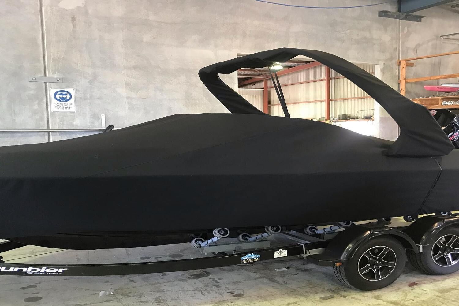 A Boat Is Covered In A Black Cover And Is On A Trailer — Currumbin Trimmers  In Currumbin Waters, QLD