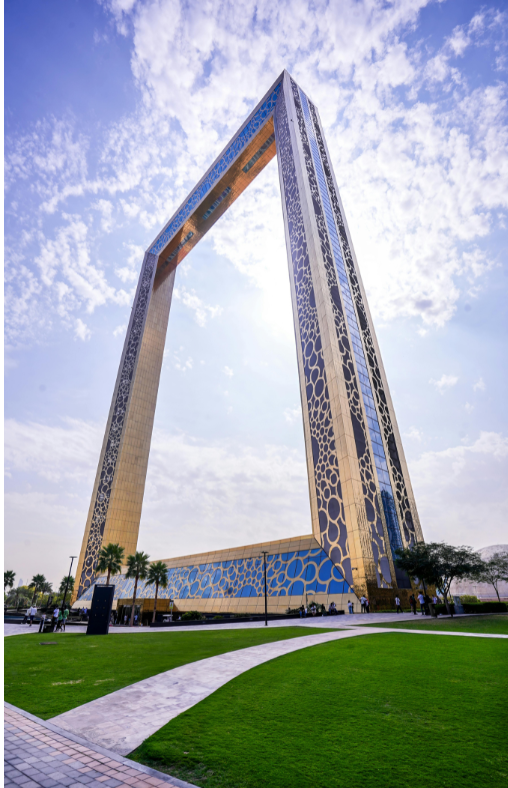 A very tall building with a very large arch in front of it.