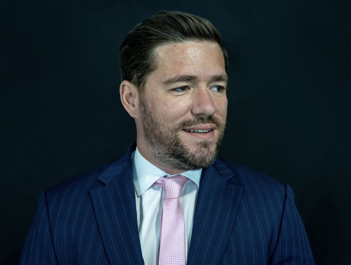 A man with a beard is wearing a suit and tie.