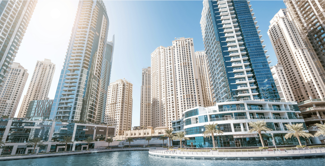 A city with a lot of tall buildings next to a body of water.