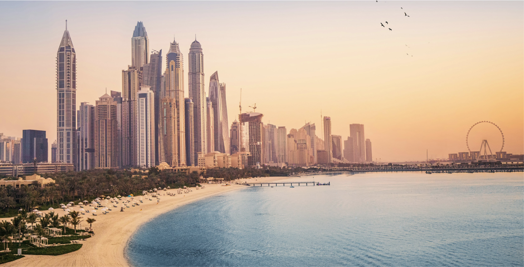 An aerial view of a city skyline with a beach in the foreground.