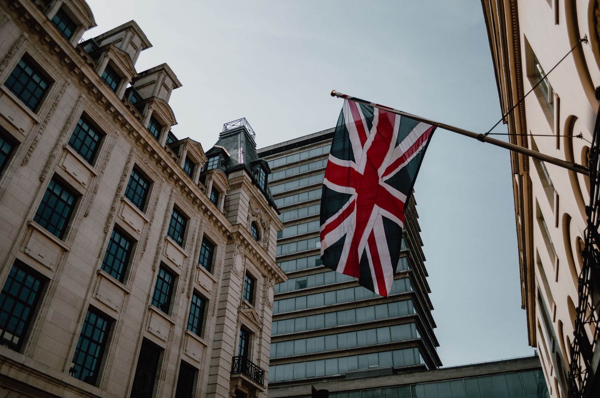 Union Jack flag hanging between city buildings on a street in London