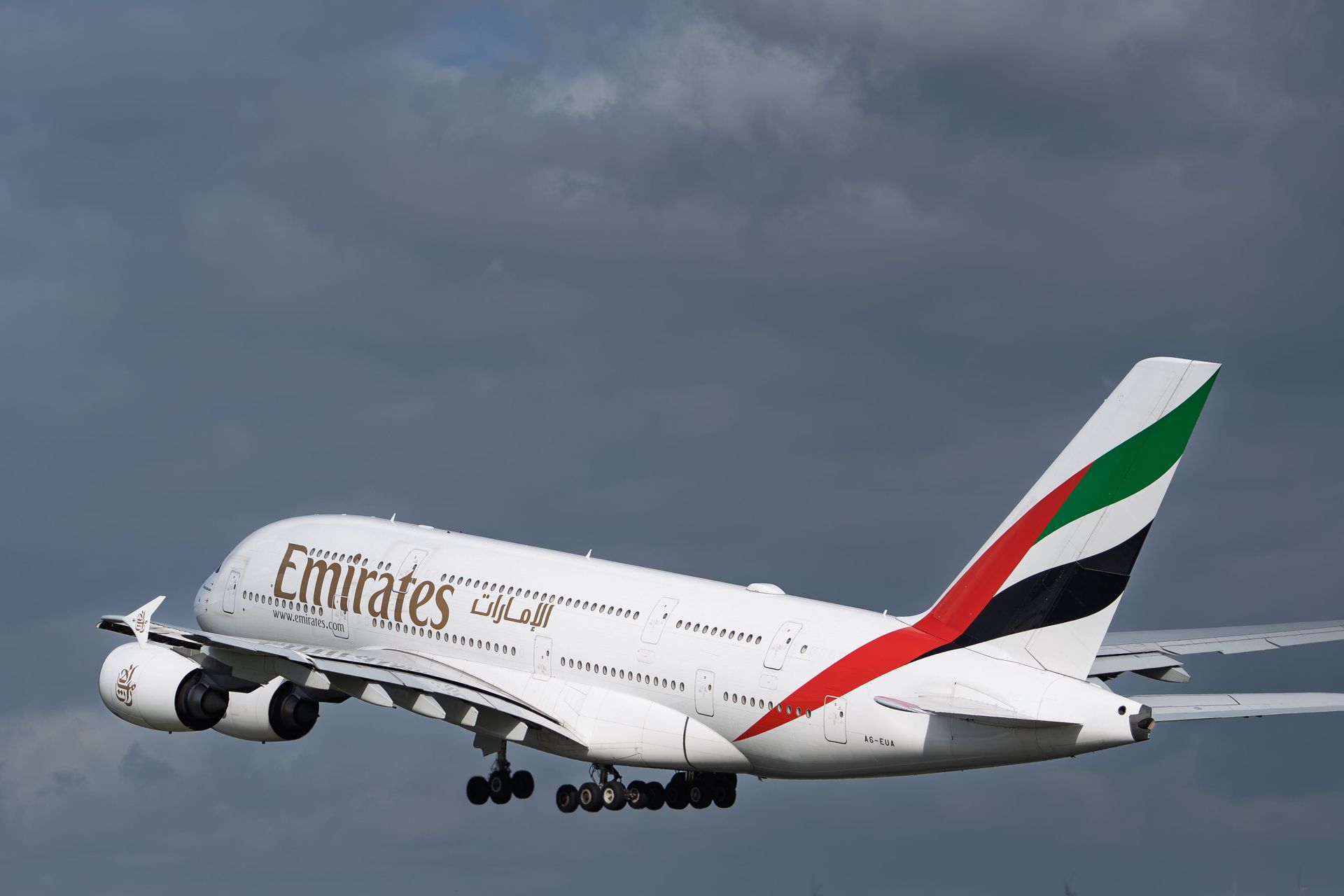 Emirates Airbus A380 taking off against a cloudy sky