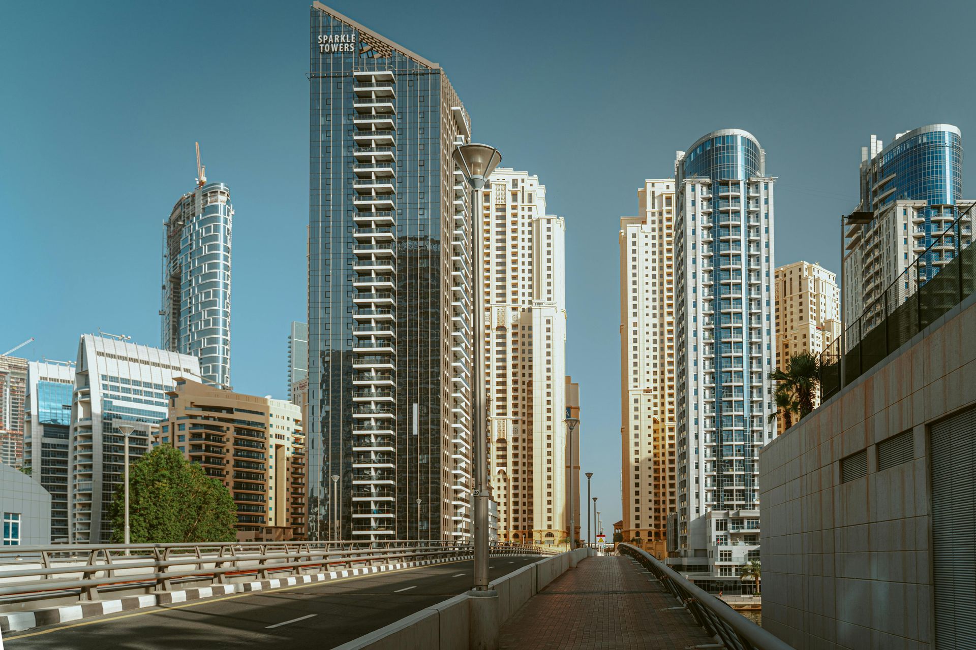 A bridge leading to a city with a lot of tall buildings.