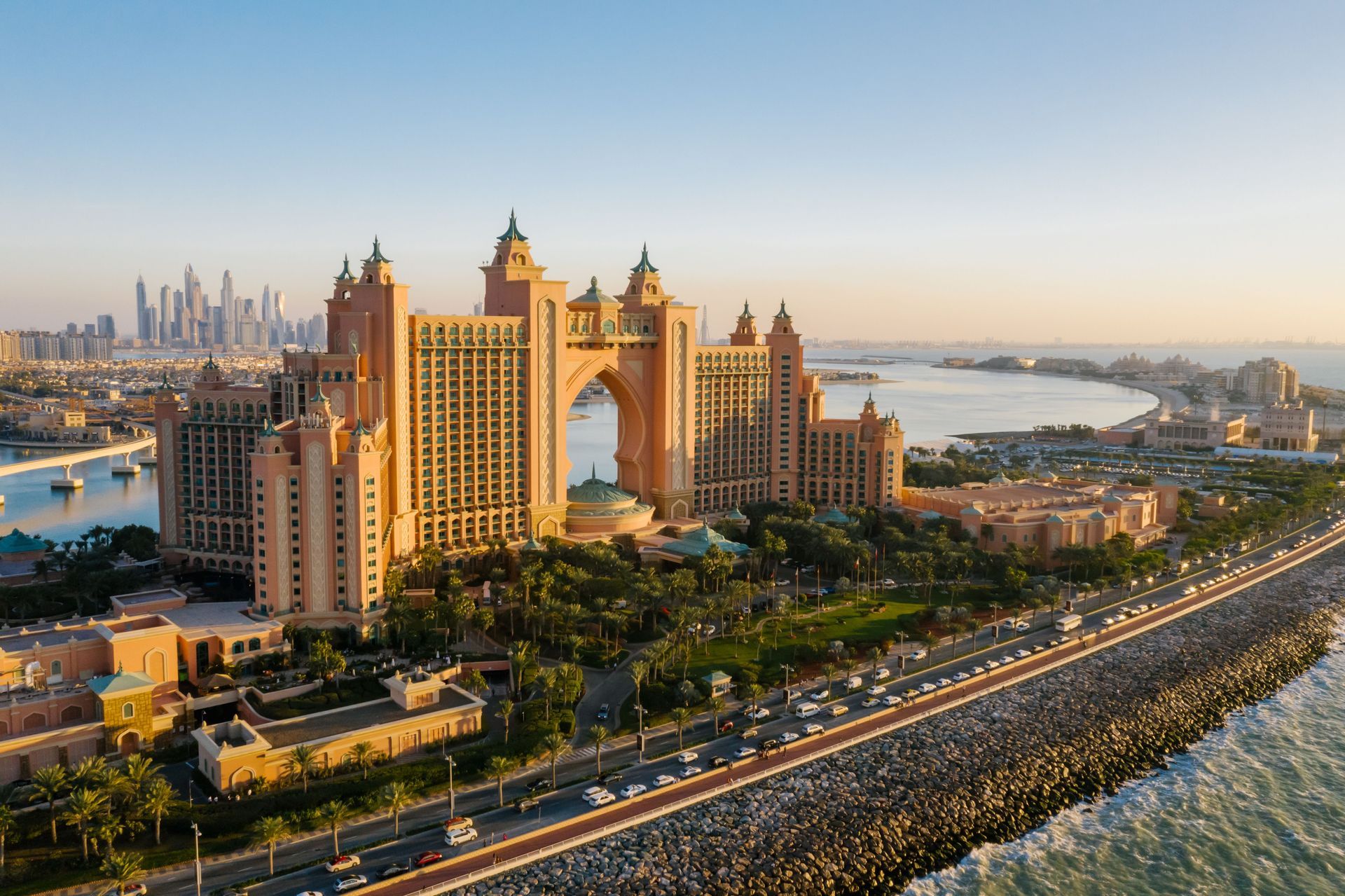 Atlantis, The Palm hotel and Dubai skyline at sunset beside a curving waterfront road