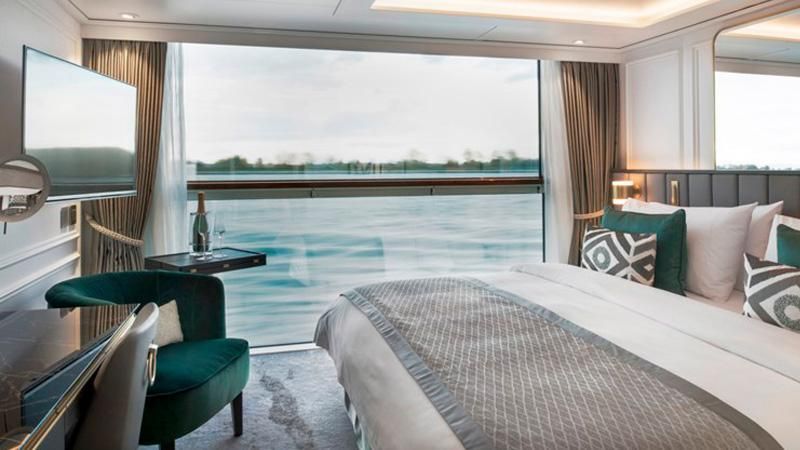 Modern hotel room with two beds, large window, and river view