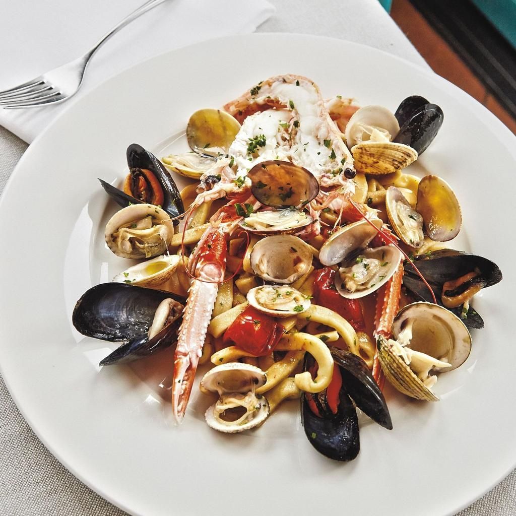 Seafood pasta on a white plate with mussels, clams, shrimp, and sauce