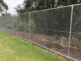 A chain link fence is sitting on top of a lush green field. — D.T. Fencing In Bakers Creek, QLD