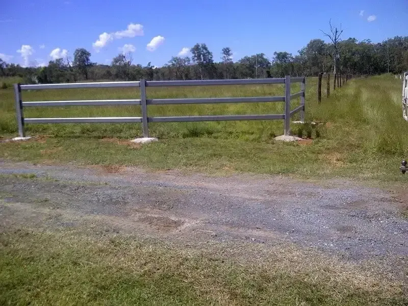 A metal fence is in the middle of a grassy field. — D.T. Fencing In Bakers Creek, QLD