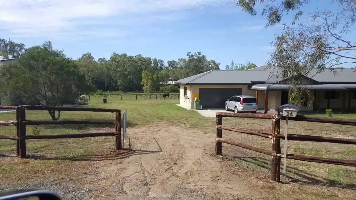 A car is parked in front of a house with a wooden fence. — D.T. Fencing In Bakers Creek, QLD