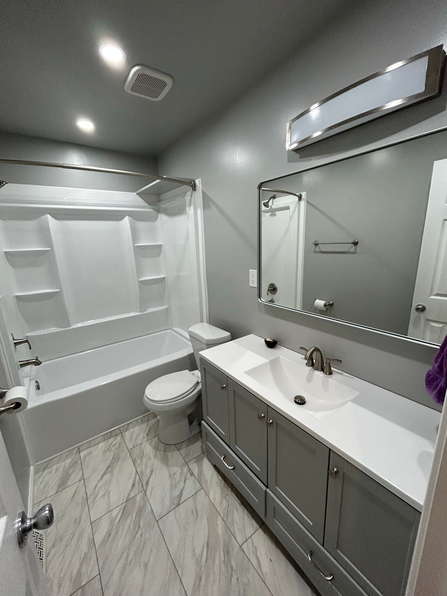 A bathroom with a sink , toilet , bathtub and mirror.