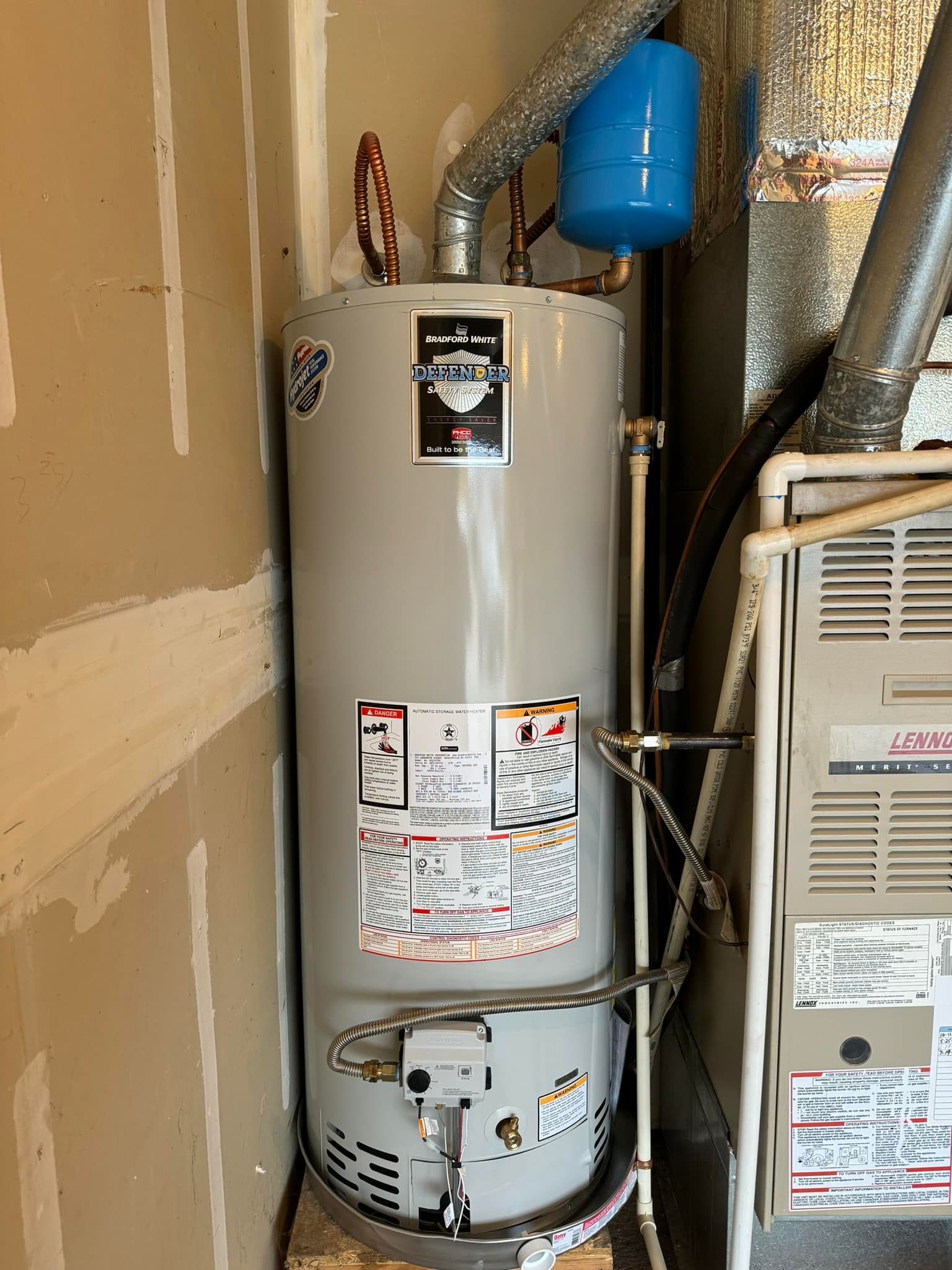 Water heater and furnace against a wall, blue expansion tank above.