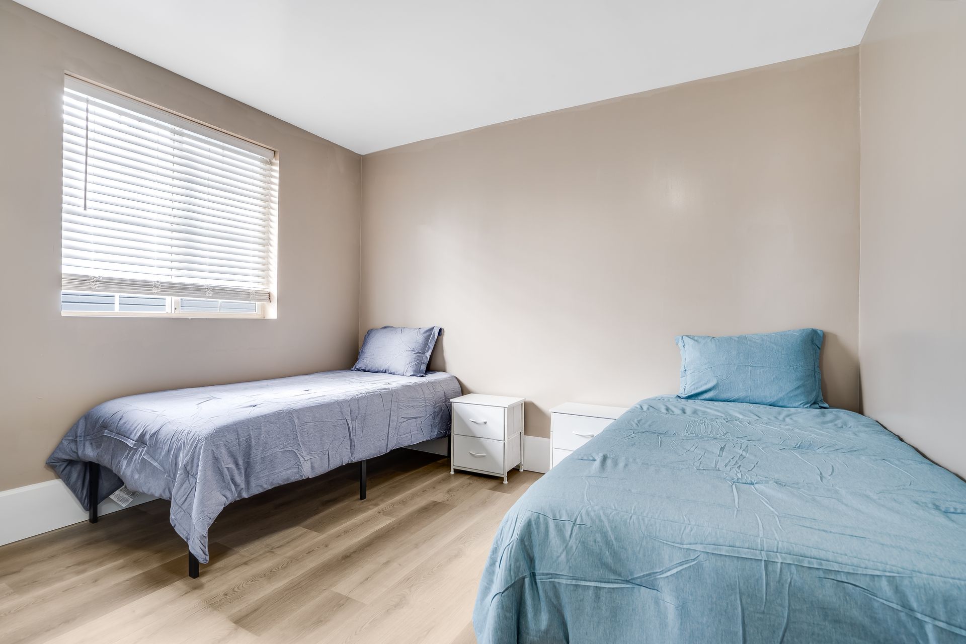 A bedroom with two beds and a window.