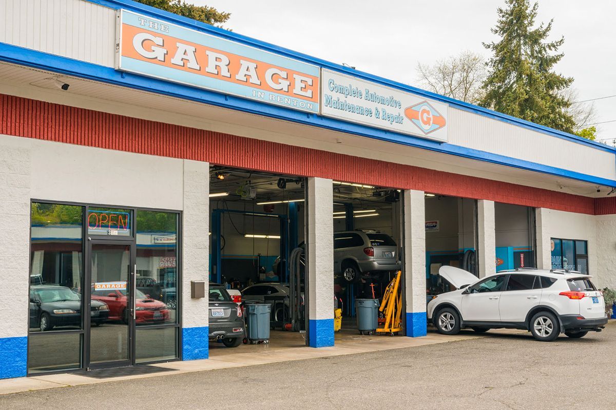 A white suv is parked in front of a garage. | The Garage in Renton