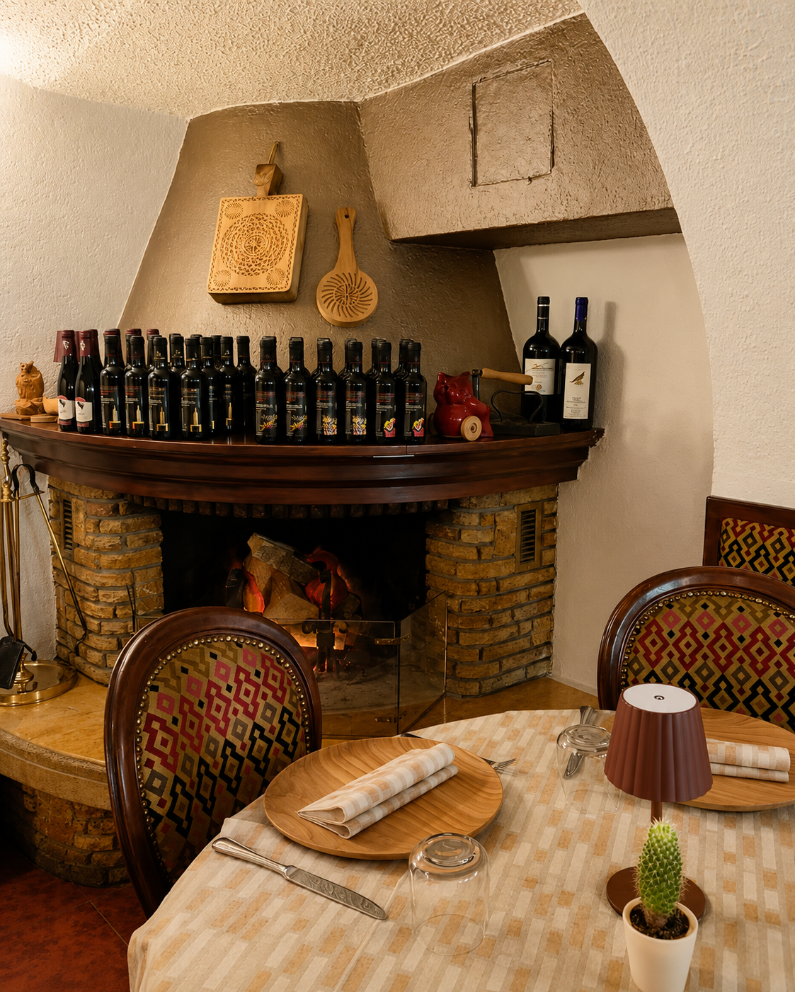 Accogliente sala da pranzo in stile rustico con bancone in legno, bottiglie di vino, sedie decorate e un tavolino apparecchiato per due.