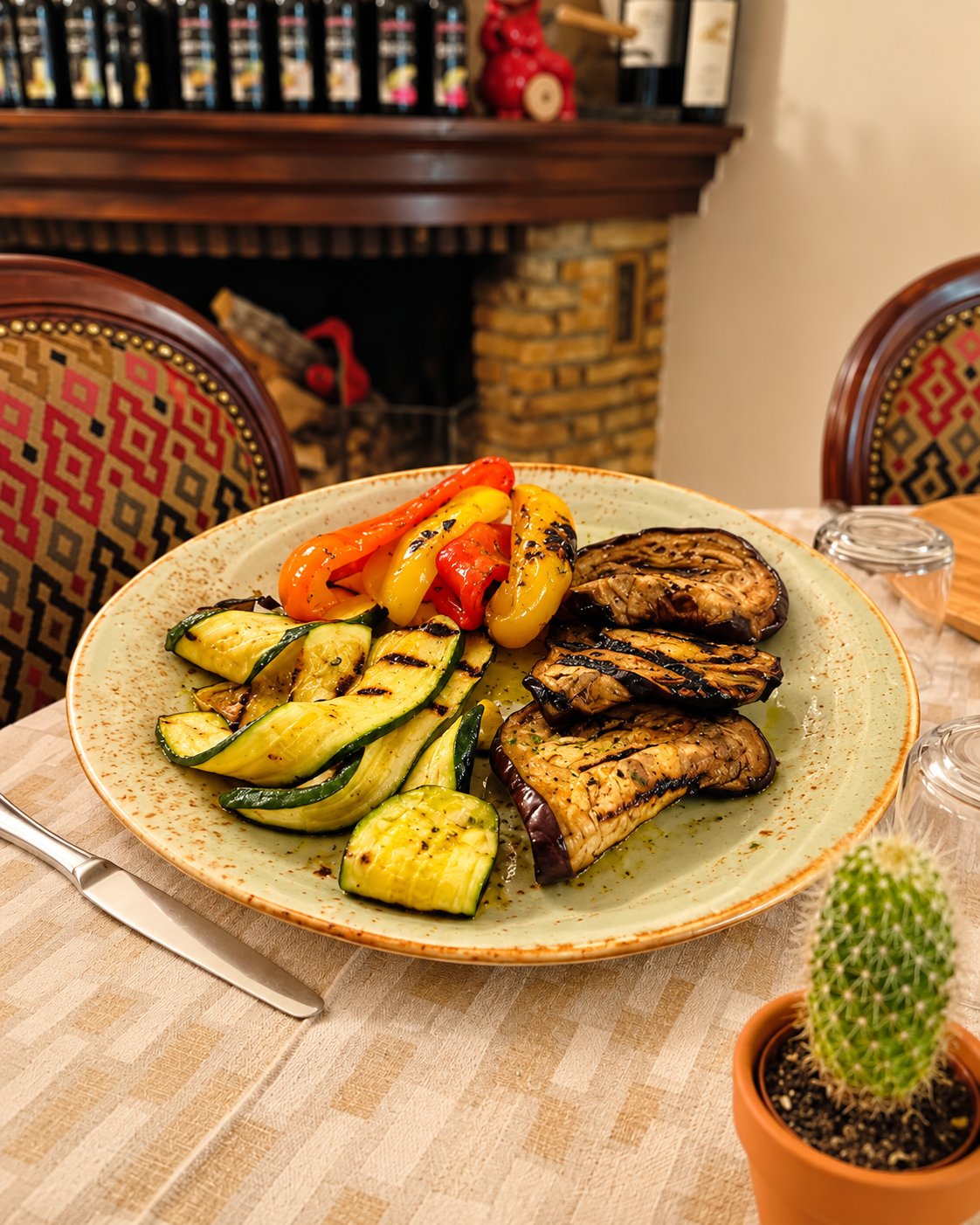 Un piatto di pollo grigliato e verdure su un tavolo, con un piccolo cactus in vaso nelle vicinanze.