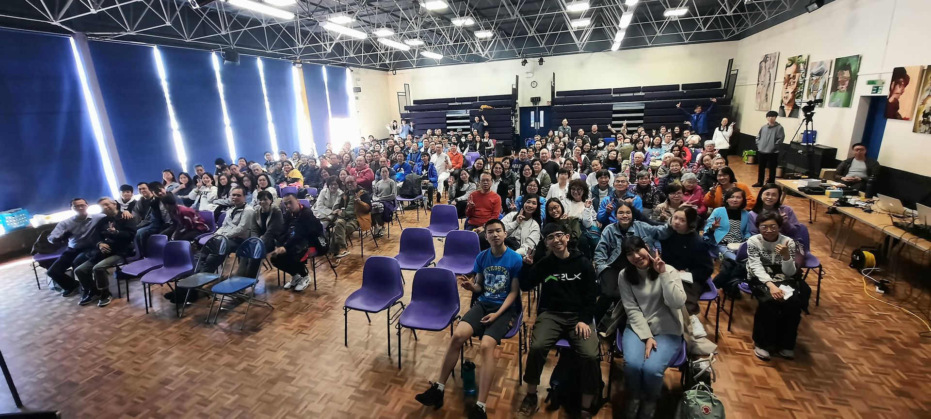 A large group of people are sitting in chairs in a large room.