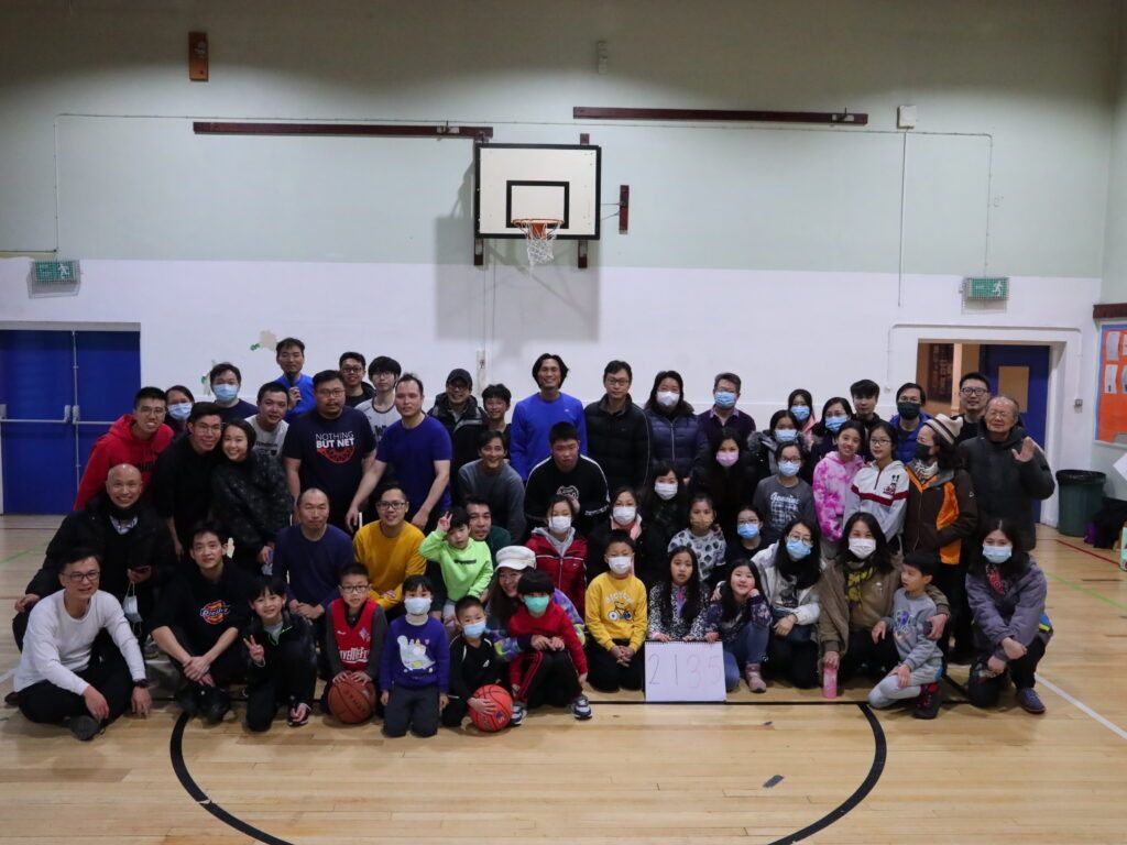 A group of people are posing for a picture on a basketball court.