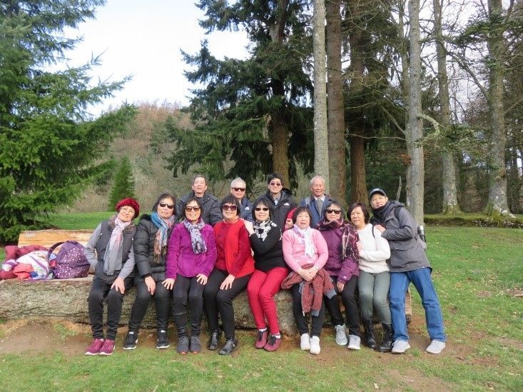 A group of people are posing for a picture in a park.