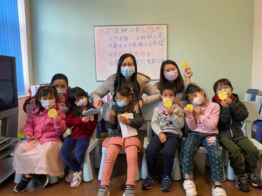 A group of children wearing face masks are posing for a picture.