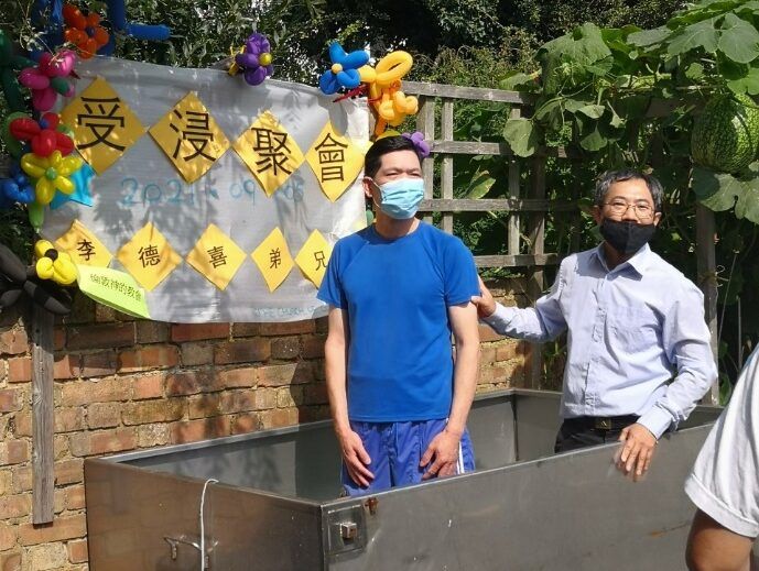 一個戴著口罩的男人站在另一個男人旁邊